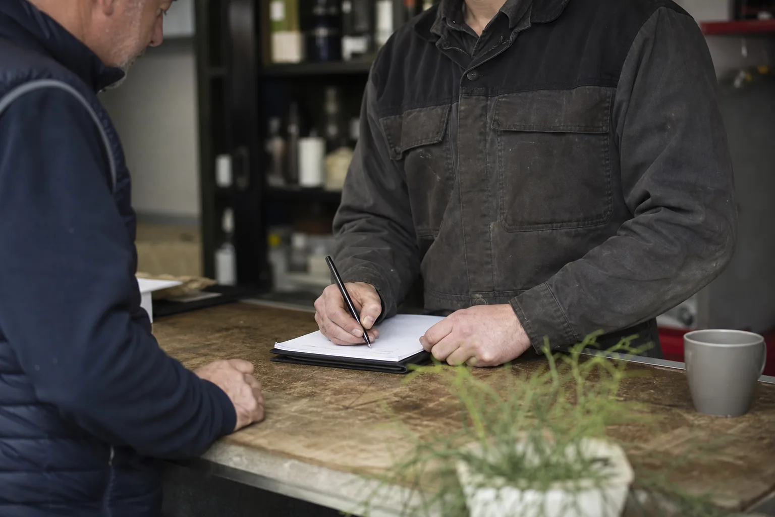 Werk in een Nederlandse winkel of werkplaats. Beeld bij het artikel: Welke gegevens horen er precies op een reparatiebon voordat de klant de werkplaats verlaat?